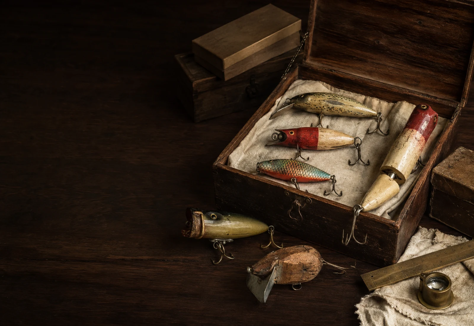 Collection of aged vintage fishing lures in an open wooden tackle box